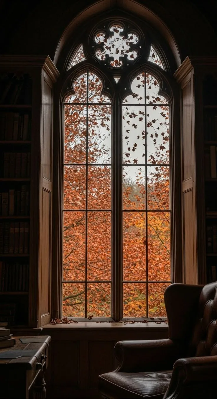Un rincón de lectura frente a una ventana con árboles de otoño
